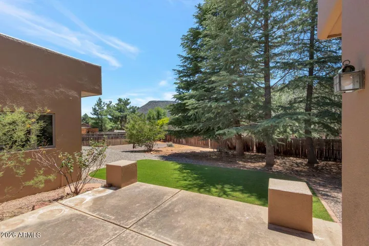 Back patio with synthetic grass and fenced in dog run area. Just over half an acre of land