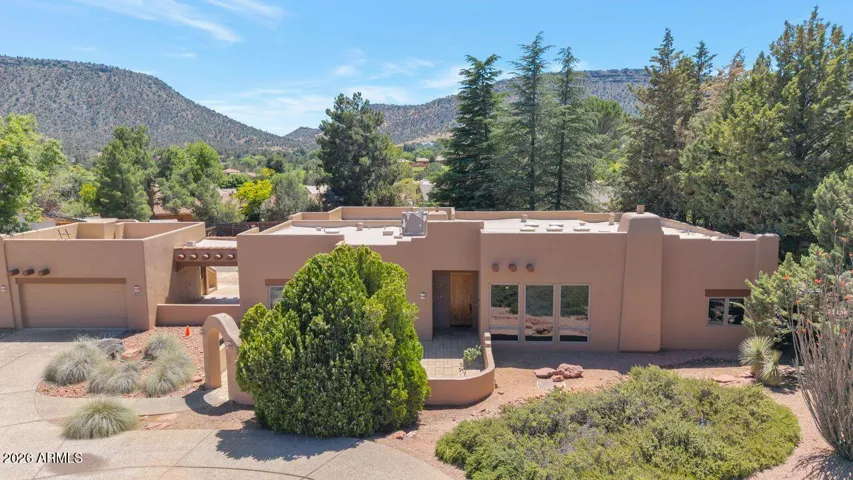 Front view with large courtyard and viewing deck above garage