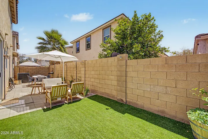 Low maintenance backyard with synthetic grass and raised garden