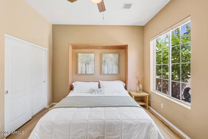 A large front-facing window fills the room with natural light, while high ceilings, a ceiling fan, and a generous closet create a comfortable, well-appointed retreat.