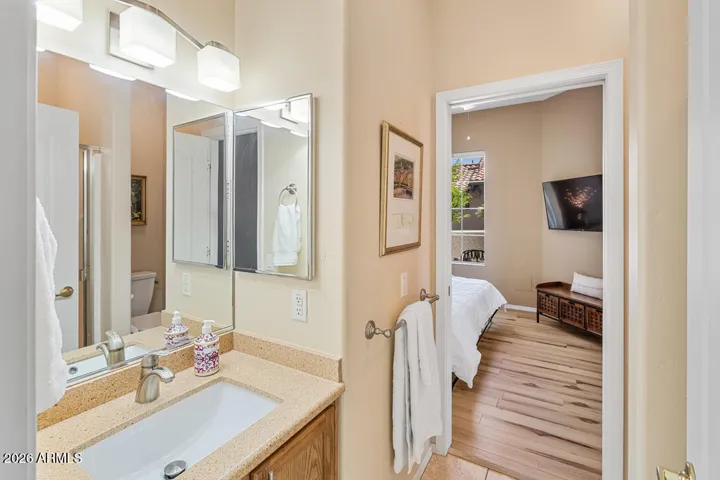 Well-appointed with a vanity, shower, and toilet, this bathroom offers convenient access from both the guest bedroom and hallway—ideal for guests and everyday ease.