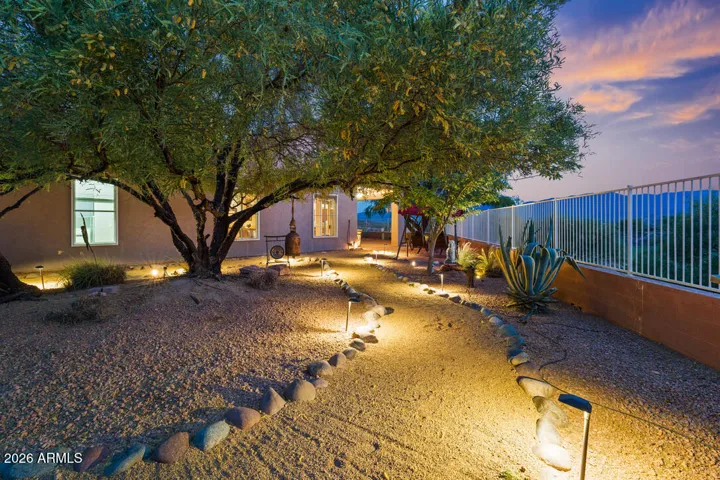 As evening settles in, this softly illuminated garden becomes a peaceful retreat—set against open skies and distant Mingus Mountain views.