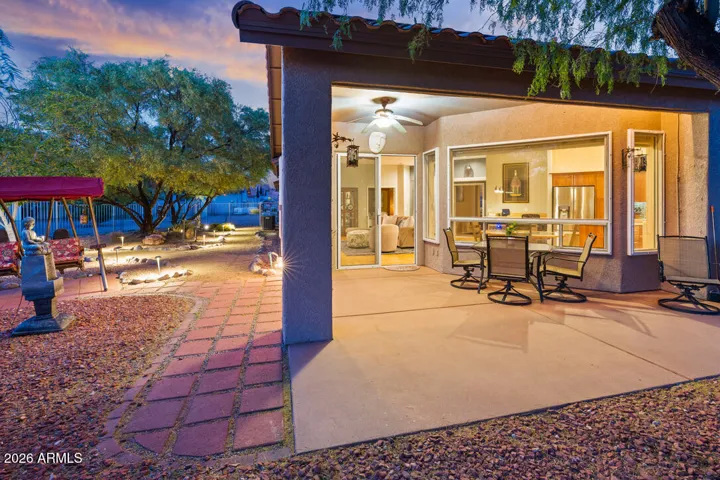 A spacious covered patio creates the perfect setting for outdoor dining and relaxed evenings, seamlessly extending the living space into a beautifully lit, tranquil backyard retreat.