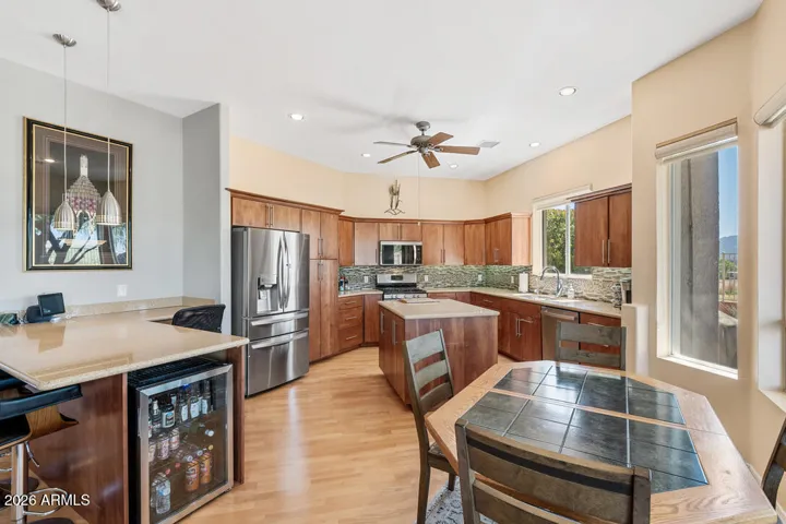 A built-in beverage center with wine fridge and bar seating creates a natural gathering spot—effortless, stylish entertaining.