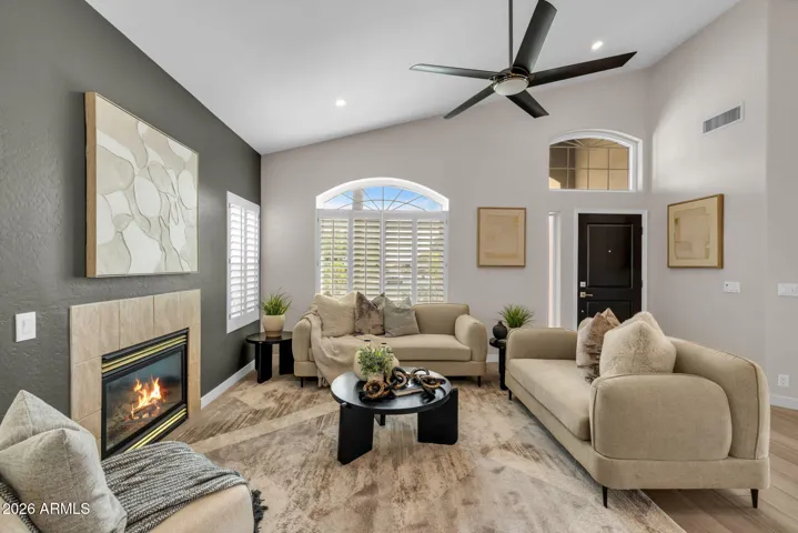 Great room with fireplace and windows with white plantation shutters.