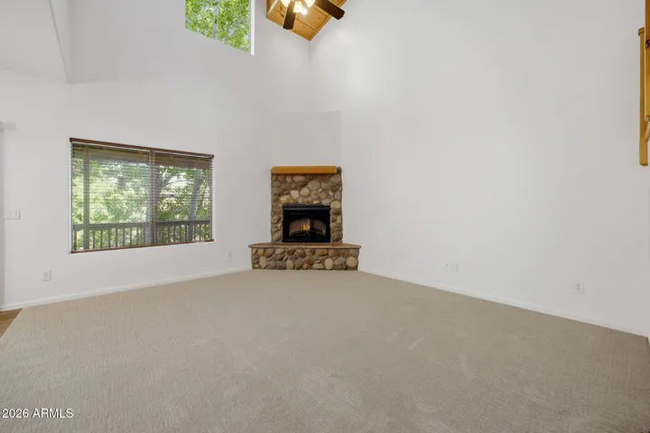 Great room with fireplace and brand new carpet and vaulted ceiling