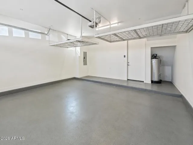 Spacious two car garage with overhead storage, clean finished flooring, and additional utility space to support both residential and business needs.