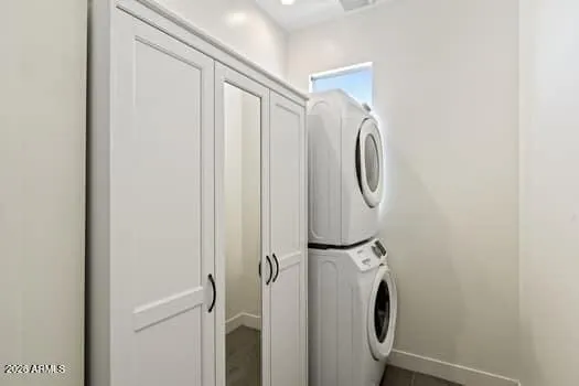 Laundry area with stacked washer and dryer, additional storage, and a functional layout.