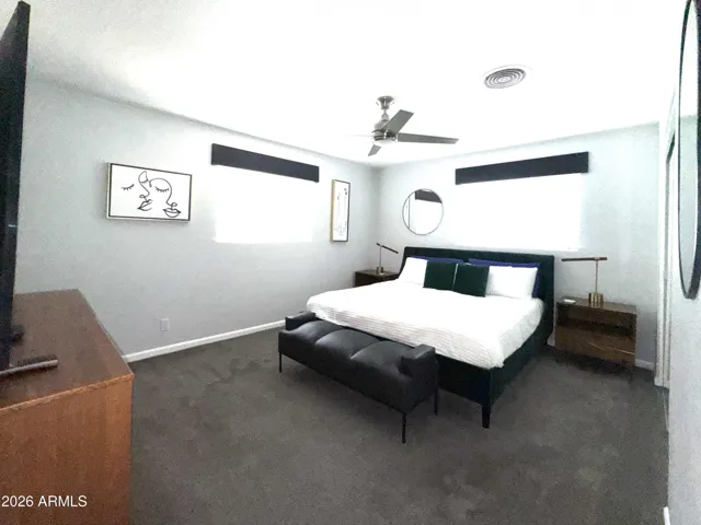 Spacious primary bedroom with window view to front yard