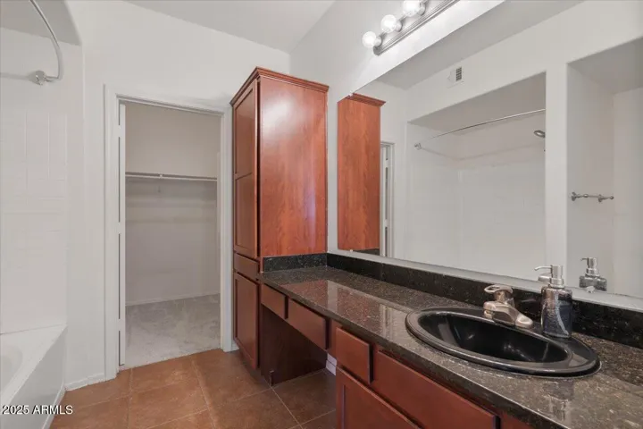 Primary Bathroom w/ extended vanity, linen storage, shower/tub combo and large walk in closet