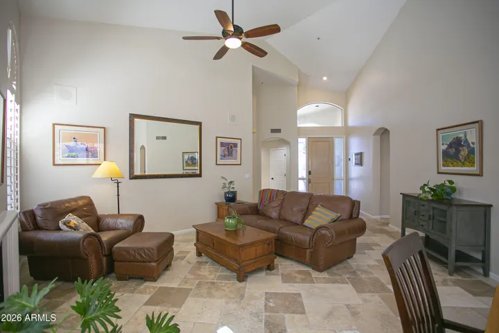 Cozy living area featuring a gas fireplace, soaring ceilings, and stunning floor-to-ceiling windows.