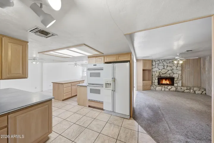 Entry to the kitchen from the dining room with an adjacent family room.