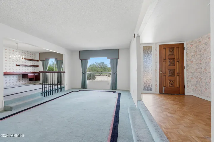Entry with parquet flooring, a formal sitting room, and a formal dining room.