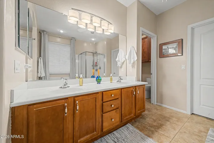 The bathroom features dual sinks, with the walk-in closet, and a separate toilet room.