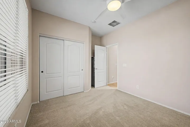 Secondary bedroom with a slider closet.