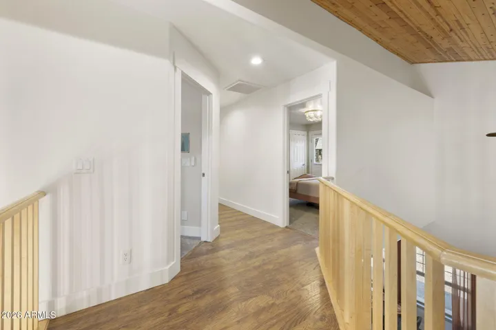 Beautiful wood walk way with open loft area leading towards guest bedrooms and bathroom.