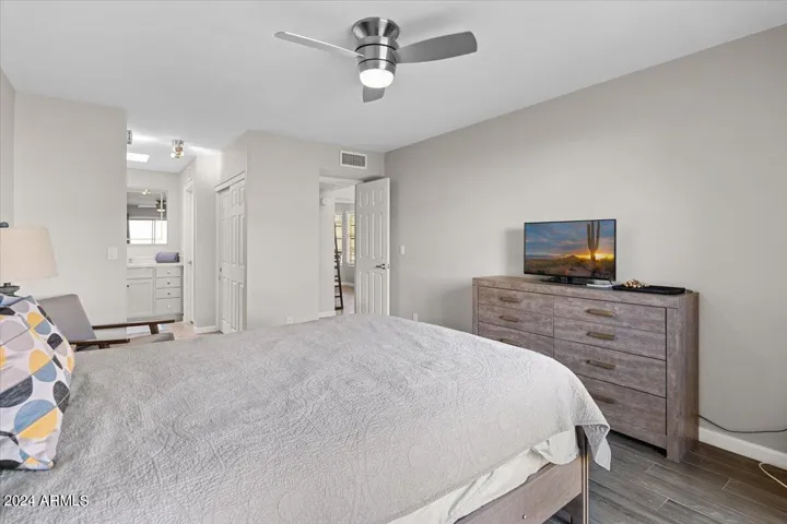 Primary suite featuring updated flooring, ceiling fan, and generous wall space