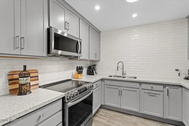 Updated kitchen with quartz counters, stainless appliances, and soft-gray cabinetry