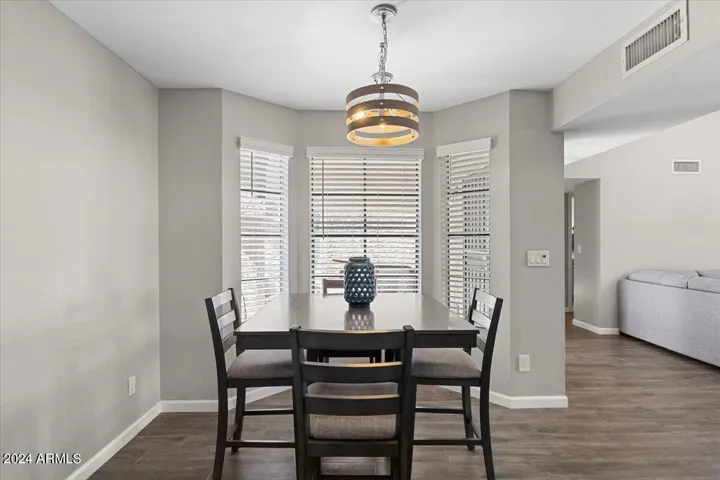 Dedicated dining space with bay windows and modern statement lighting
