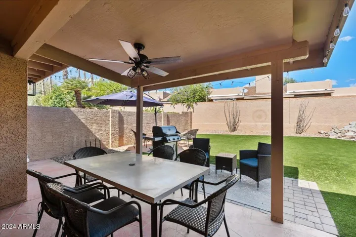 Private backyard retreat with covered patio, turf lawn, and entertaining space
