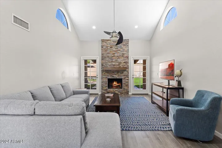Light-filled living room with vaulted ceilings and dramatic stone fireplace