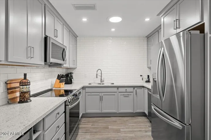 Bright, modern kitchen featuring subway tile backsplash and ample storage