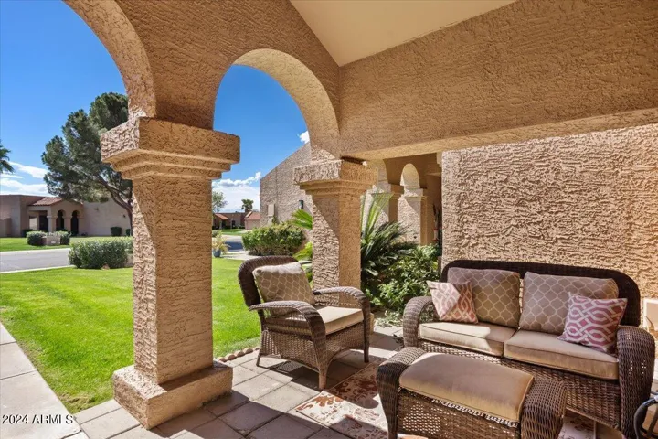 Inviting covered front patio with arched columns—perfect for morning coffee