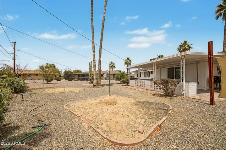 This spacious backyard offers low-maintenance desert landscaping and plenty of room to enjoy the Arizona sunshine. With a chain link fencing, covered patio, mature palms, and open outdoor space, it’s easy to imagine relaxing, gardening, or creating your own outdoor retreat in this Sun City home.