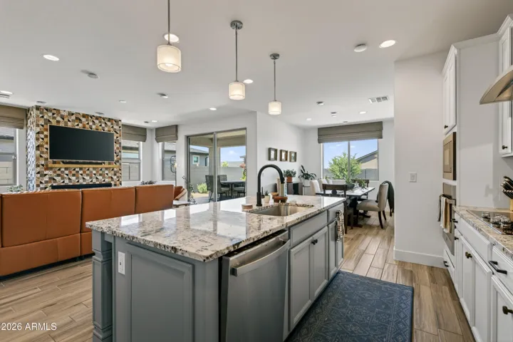 Open-concept kitchen with a large island flowing into a bright dining and living area.