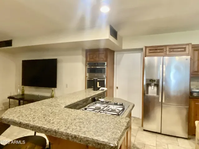 Knotty Pine cabinetry with timeless granite counters and travertine floors