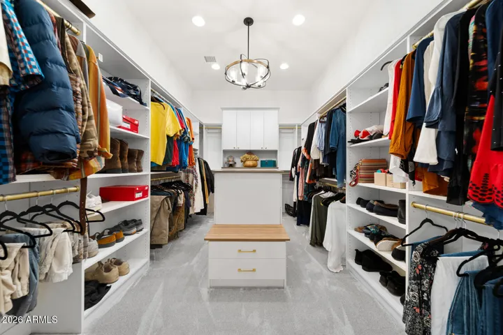 Dream walk-in closet with built-ins, center storage & chandalier
