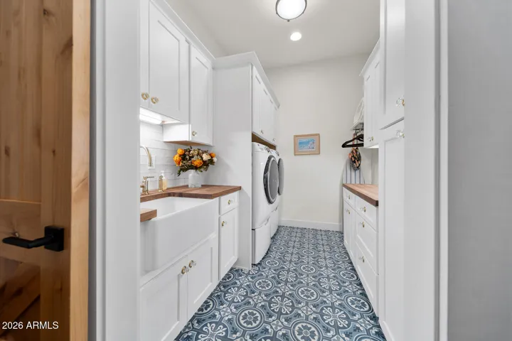Laundry room with front load washer/dryer, sink and lots of storage.