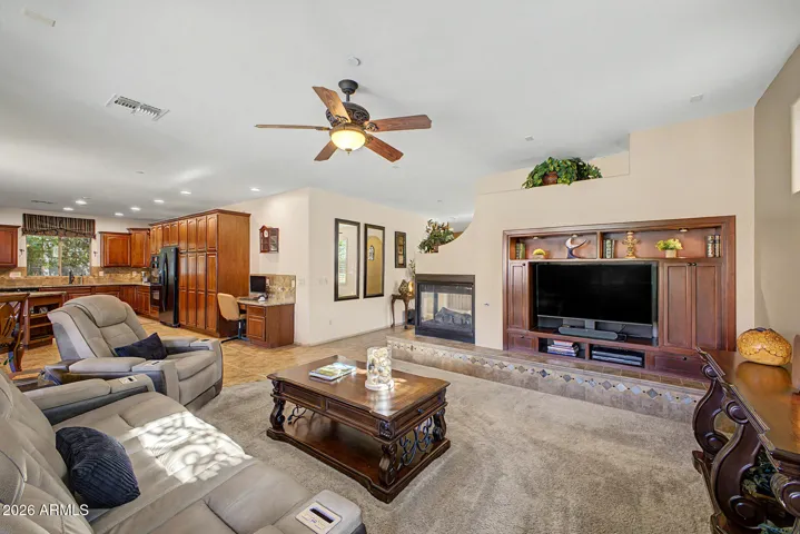 The living room’s two-way fireplace seamlessly connects to the family room, setting the stage for lively gatherings or peaceful evenings by the fire.