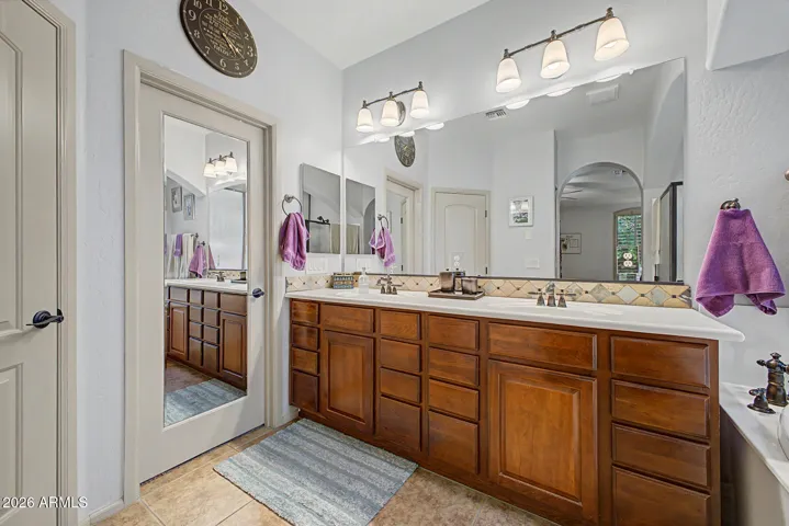 The owner’s suite is a private sanctuary, offering an ensuite bathroom with dual vanities, a luxurious jetted tub, a spacious walk-in shower, and a generous walk-in closet.
