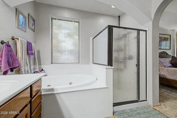 The owner’s suite is a private sanctuary, offering an ensuite bathroom with dual vanities, a luxurious jetted tub, a spacious walk-in shower, and a generous walk-in closet.