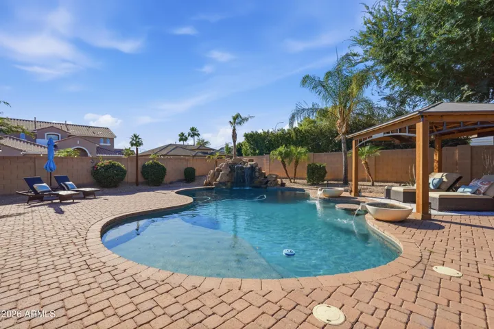 Pebble Tec pool w/ baja shelf & in-water table seating, grotto waterfall, bowl water features