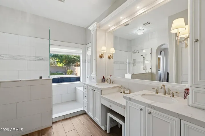 luxurious upgraded bath w/ expanded tiled shower, multiple shower heads & bench seating