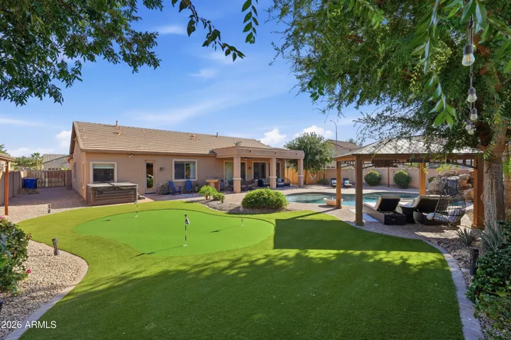 Large putting green and mature landscaping.