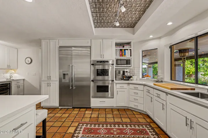 High-end appliances, gas cooking, double ovens, quartz & Saltillo, custom cabinets.