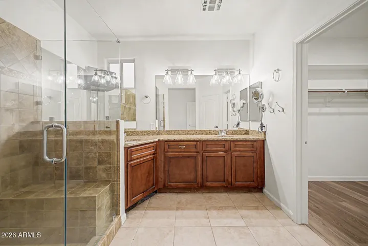 Primary bath with tiled shower and double sinks.