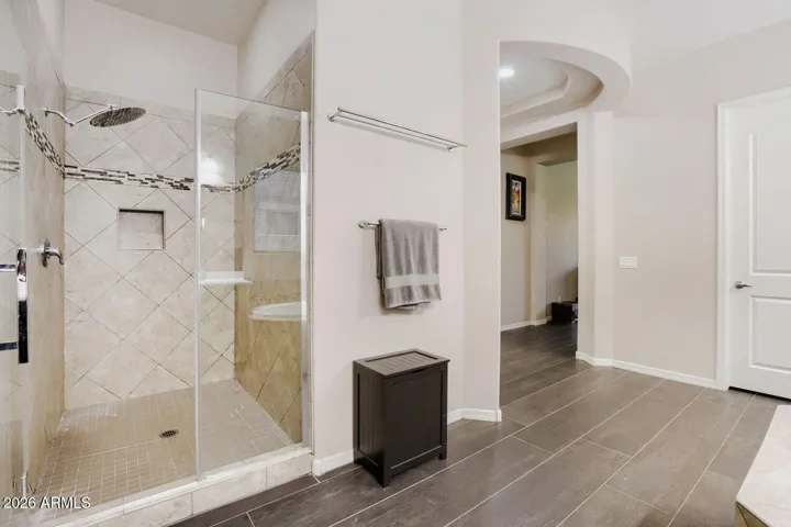 Glass walk in shower, private toilet room, and access to two separate walk in closets designed for comfort and functionality.
