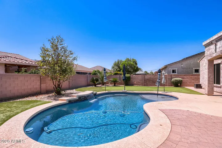 Private pool with water feature, putting green and fire pit creates a relaxing backyard setting for outdoor enjoyment and entertaining.