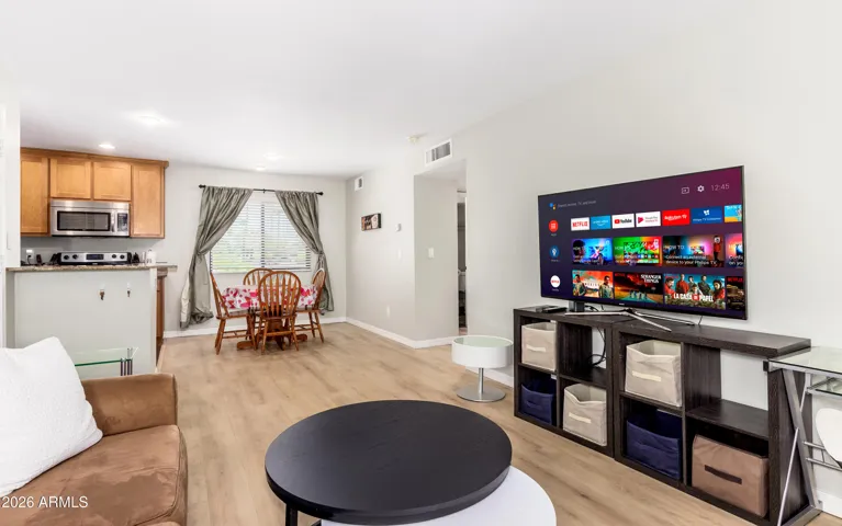 "Light-filled living space with comfortable seating, smart TV, and a bright patio view — your home base away from home."