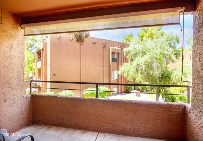 "The view from your private balcony — lush greenery, mature Pine trees, and the quiet of a well-kept gated community. Your daily decompression zone."