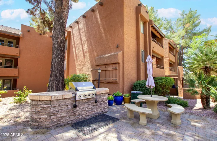 "Fire up the built-in community BBQ — stone grill station, outdoor seating, and shade trees. Weekend cookouts are part of the lifestyle here."