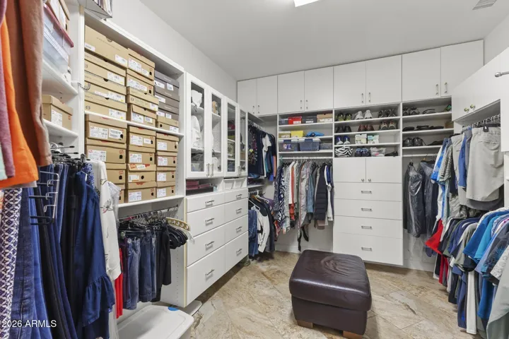 The large walk-in closet has custom built ins - a place for everything, including seating for putting on shoes.