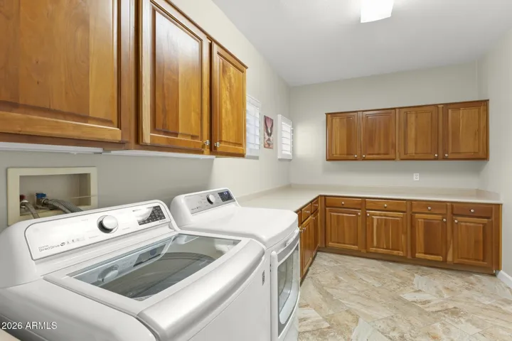 The inside laundry room has beautiful cherry cabinets and plenty of them, along with lots of counter space for folding