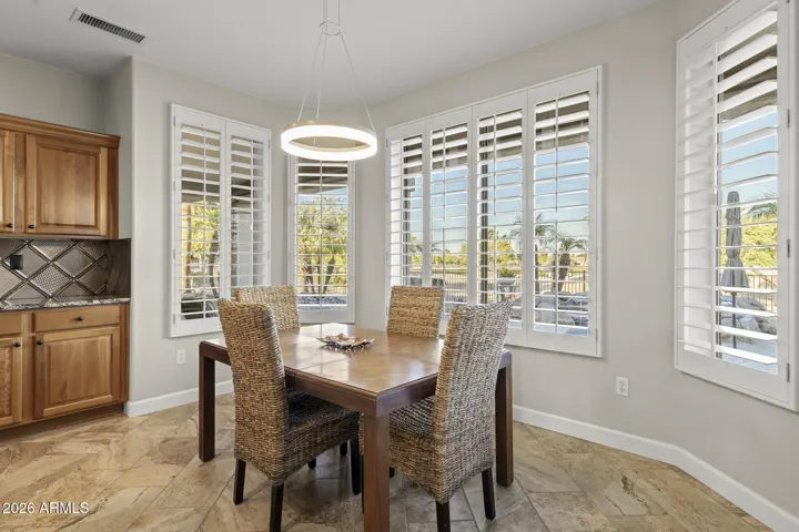 The stylish dining space features a bay window offering a panoramic view of the golf course.