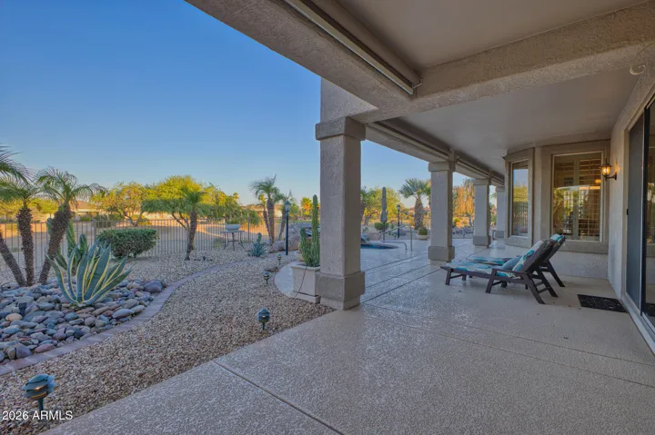 The extended, covered back patio has a cool deck surface. This photo is taken outside of the primary suite and facing south.