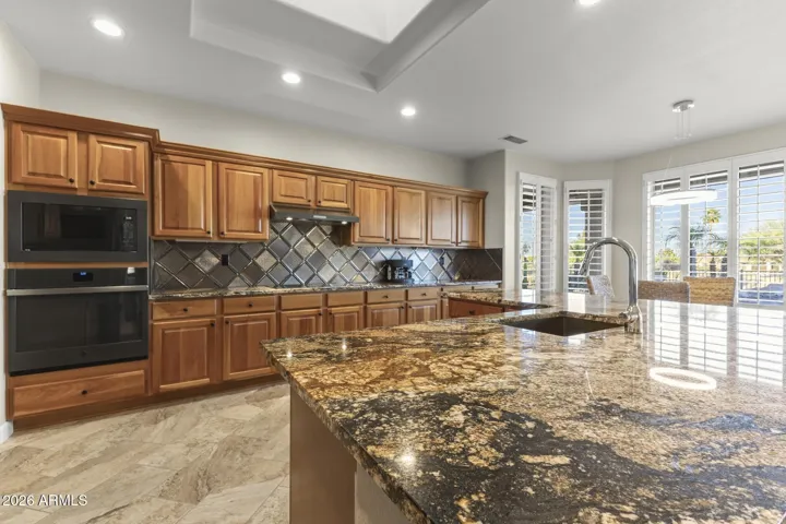 This kitchen has it all. Lots of cherry cabinets, granite countertops, an undermount composite sink and a huge breakfast bar for added dining.